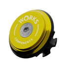 A upper bearing cover and Works Components branded top-cap in shiny anodised gold with a black seal designed to work with all our angle and reach headsets.